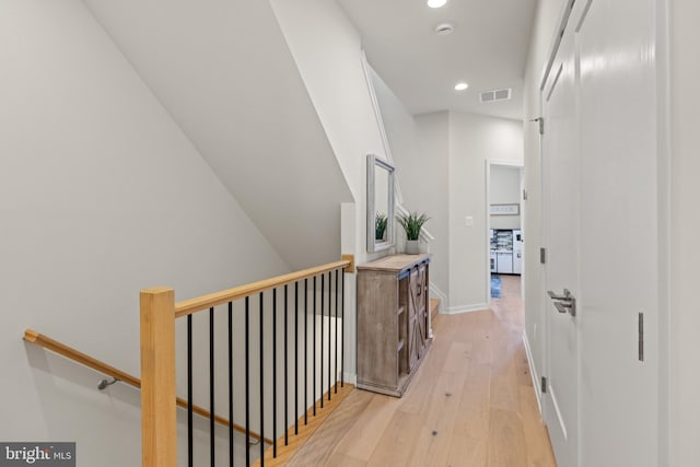 corridor with visible vents, baseboards, an upstairs landing, light wood-style flooring, and recessed lighting