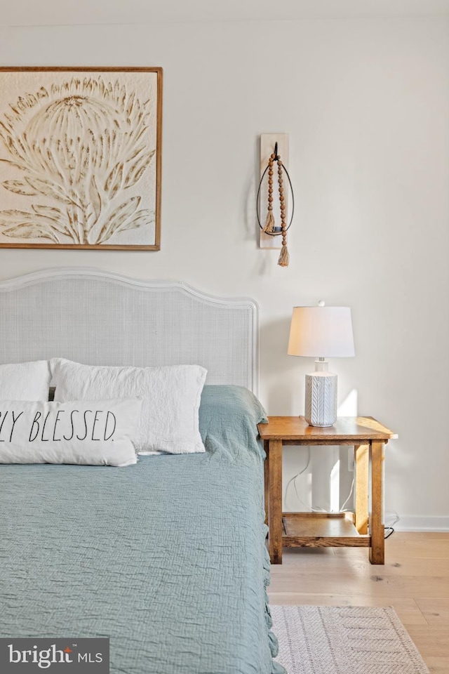 bedroom with baseboards and wood finished floors