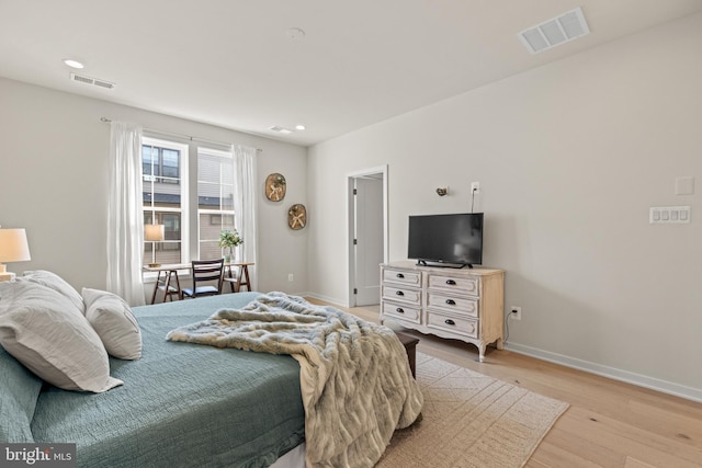 bedroom featuring baseboards, visible vents, and light wood-type flooring