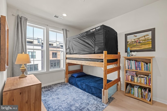 bedroom with recessed lighting, visible vents, baseboards, and wood finished floors