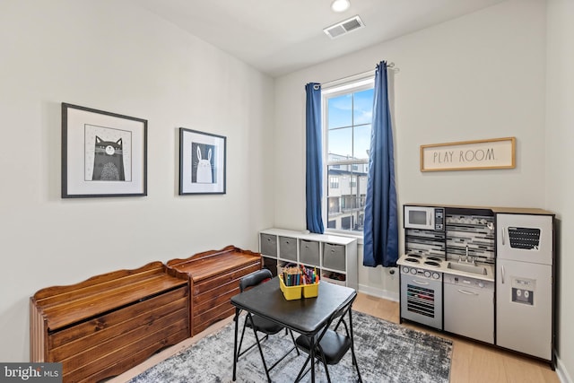 interior space featuring light wood-type flooring, visible vents, and baseboards