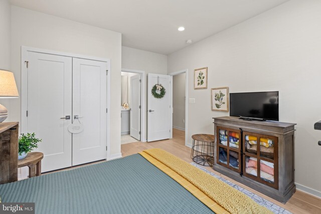 bedroom featuring light wood finished floors, recessed lighting, a closet, and baseboards