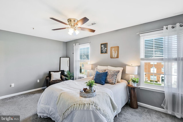 bedroom with carpet flooring, visible vents, a ceiling fan, and baseboards