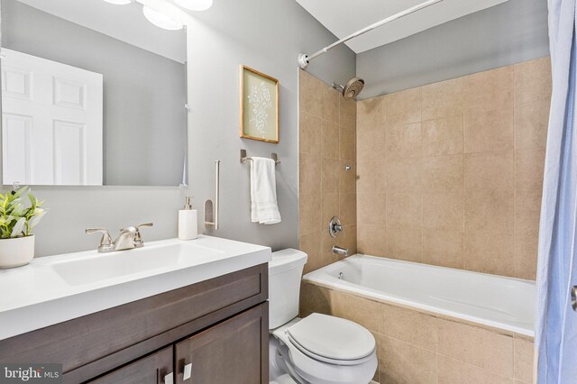 full bath featuring toilet, vanity, and tiled shower / bath combo