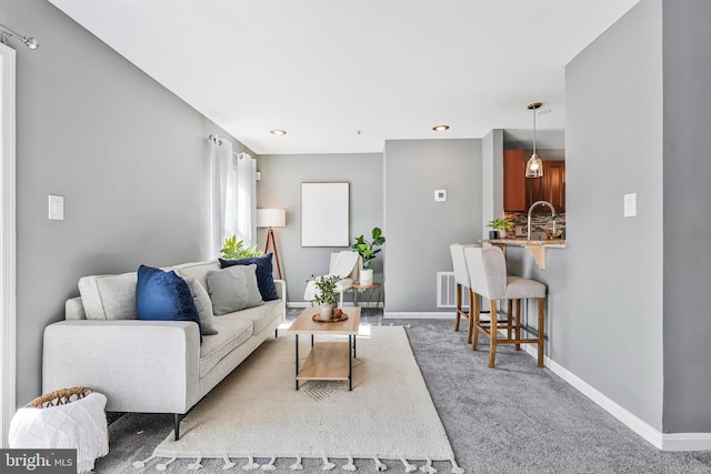 living area featuring baseboards and carpet