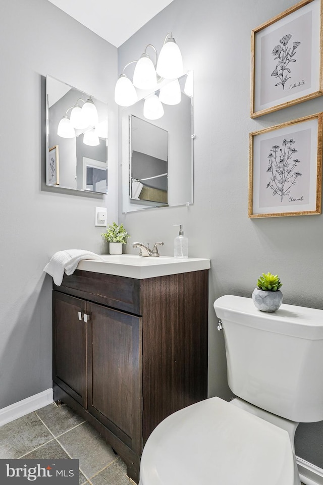 half bath featuring baseboards, toilet, and vanity