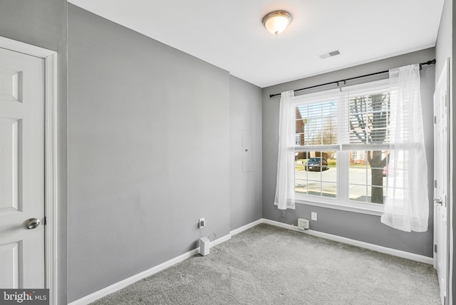 spare room featuring carpet flooring, baseboards, and visible vents