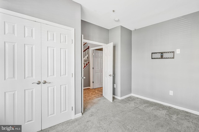 unfurnished bedroom featuring a closet, baseboards, and carpet flooring