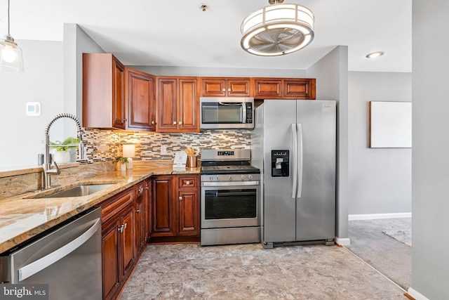 kitchen with tasteful backsplash, baseboards, light stone countertops, stainless steel appliances, and a sink