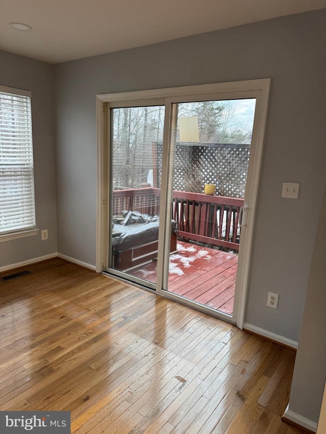 doorway featuring baseboards and hardwood / wood-style floors