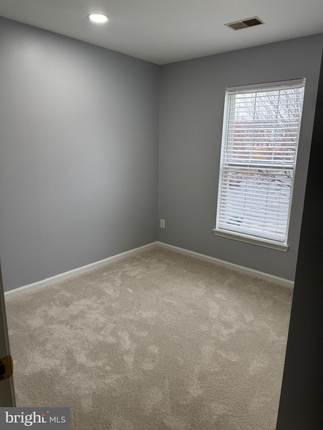 empty room featuring visible vents, recessed lighting, baseboards, and carpet floors