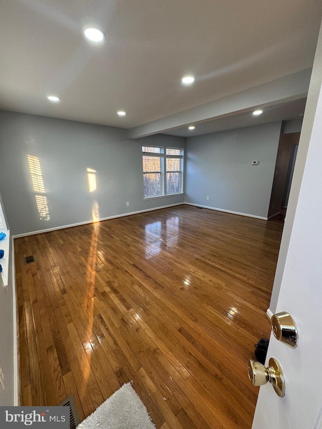 unfurnished room featuring visible vents, recessed lighting, baseboards, and hardwood / wood-style floors