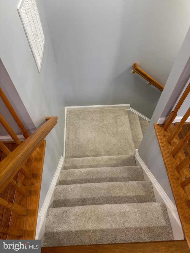 stairs with visible vents and baseboards