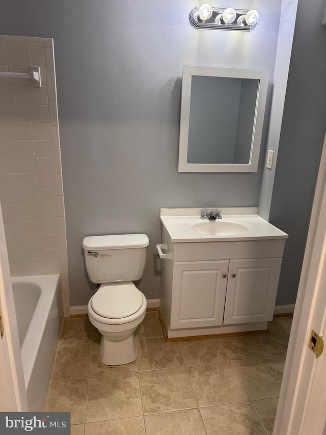 bathroom featuring vanity, toilet, baseboards, and tile patterned flooring