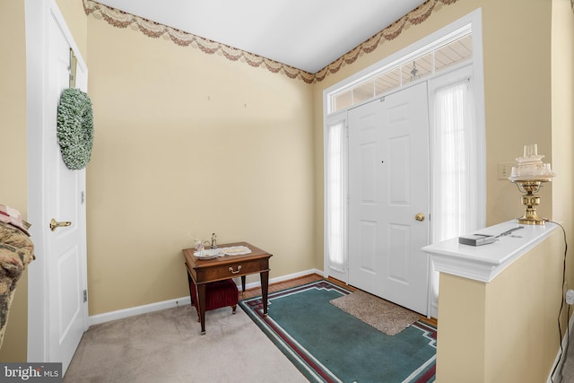 foyer with light colored carpet and baseboards