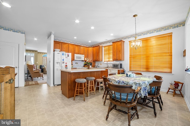 dining space with a toaster, recessed lighting, baseboards, and an inviting chandelier