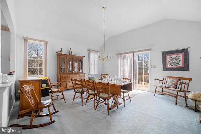 dining space featuring vaulted ceiling, a notable chandelier, and light colored carpet