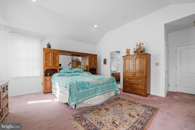 bedroom with ensuite bath, vaulted ceiling, baseboards, and light carpet