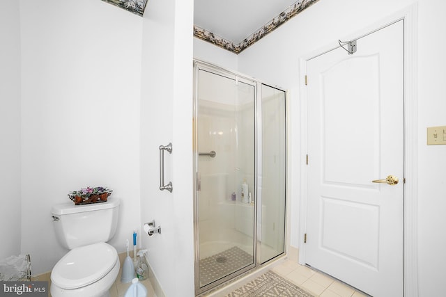 bathroom featuring tile patterned flooring, a shower stall, and toilet