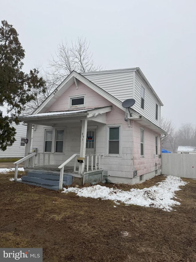 bungalow-style house featuring a porch and fence