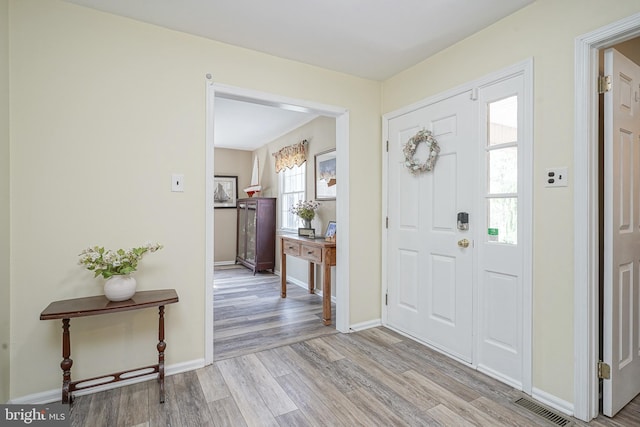 entryway with visible vents, light wood-style flooring, and baseboards