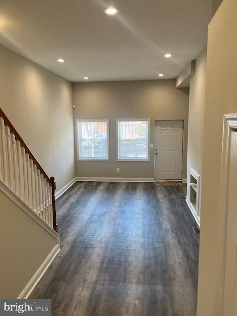 unfurnished living room with recessed lighting, baseboards, and dark wood-style floors