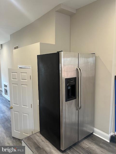 kitchen with visible vents, wood finished floors, stainless steel refrigerator with ice dispenser, and baseboards