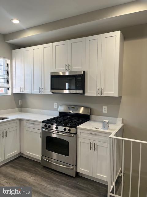 kitchen featuring light countertops, recessed lighting, stainless steel appliances, dark wood-style floors, and white cabinetry