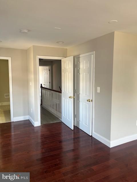 empty room with baseboards and wood finished floors