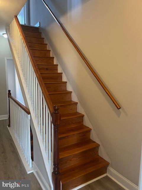 stairs featuring baseboards and wood finished floors