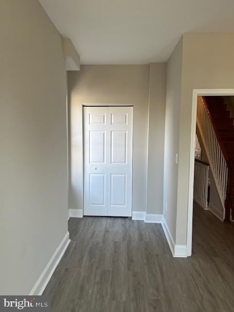 unfurnished bedroom featuring a closet, baseboards, and wood finished floors