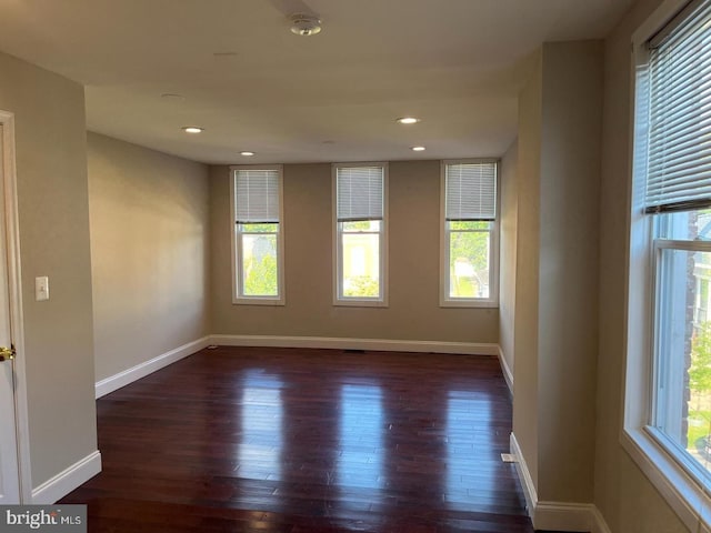 spare room with recessed lighting, baseboards, and dark wood-style flooring