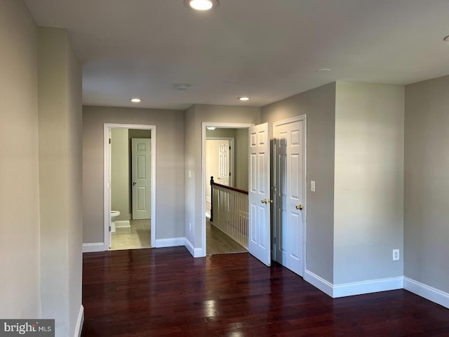 unfurnished room featuring recessed lighting, wood finished floors, and baseboards