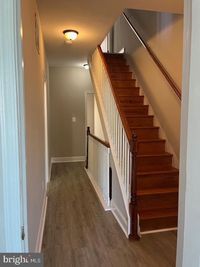 stairway with visible vents, baseboards, and wood finished floors