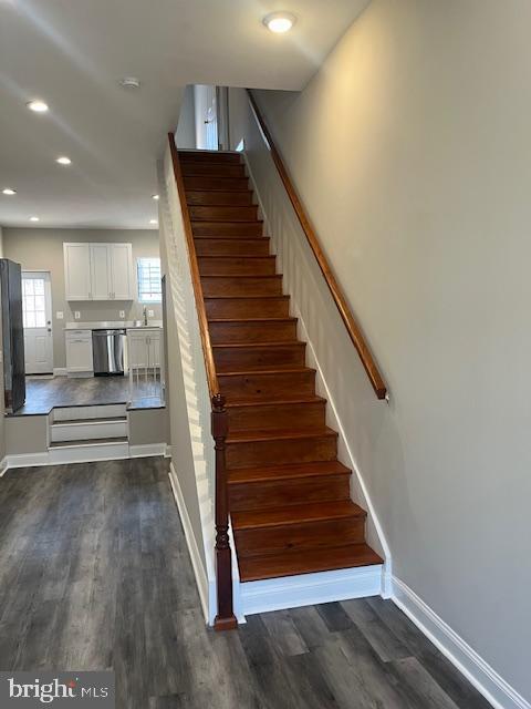 staircase with recessed lighting, baseboards, and wood finished floors