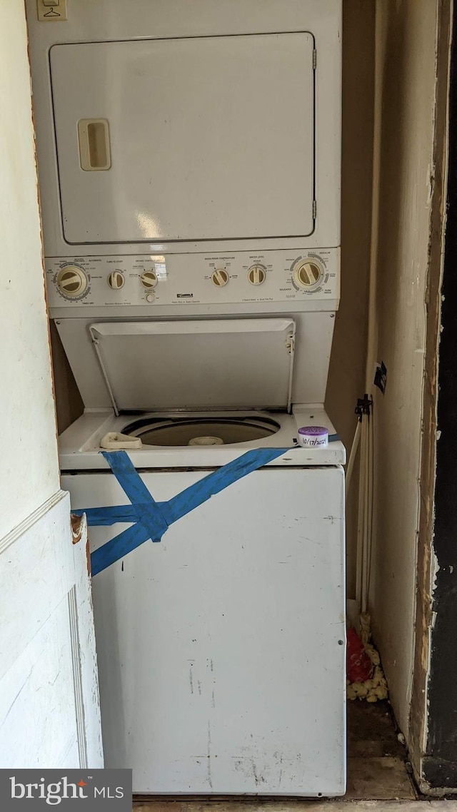 clothes washing area with laundry area and stacked washer and dryer