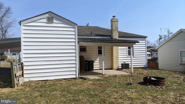 back of property featuring central air condition unit and a shingled roof