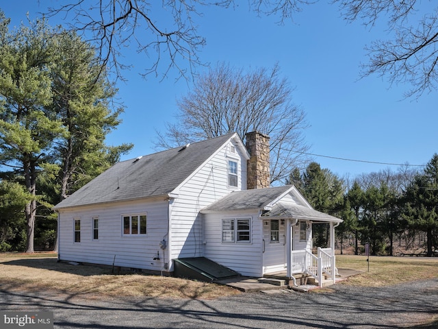 view of property exterior featuring roof with shingles and a chimney