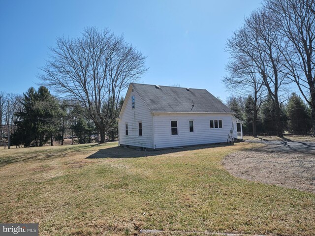 back of property with a lawn and a shingled roof