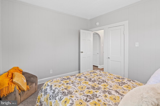 bedroom featuring baseboards and arched walkways