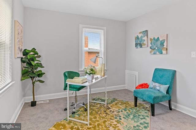 living area with visible vents, baseboards, and carpet floors