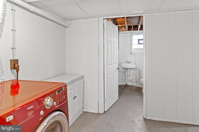 clothes washing area with a sink, laundry area, and washer and clothes dryer