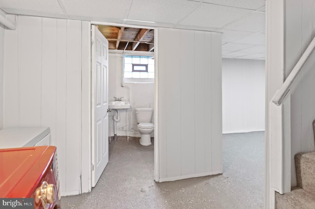 bathroom with a sink, a drop ceiling, separate washer and dryer, and toilet