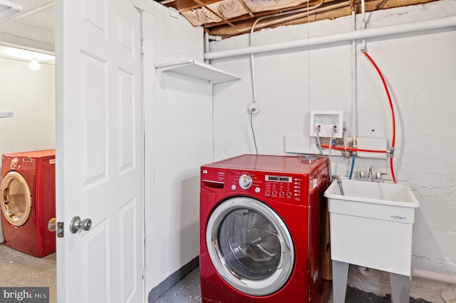 laundry room with laundry area, separate washer and dryer, and a sink