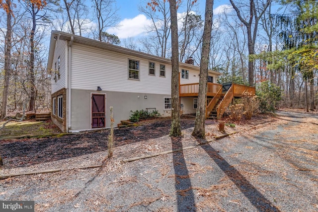 view of front of property with stairway, a wooden deck, and a chimney