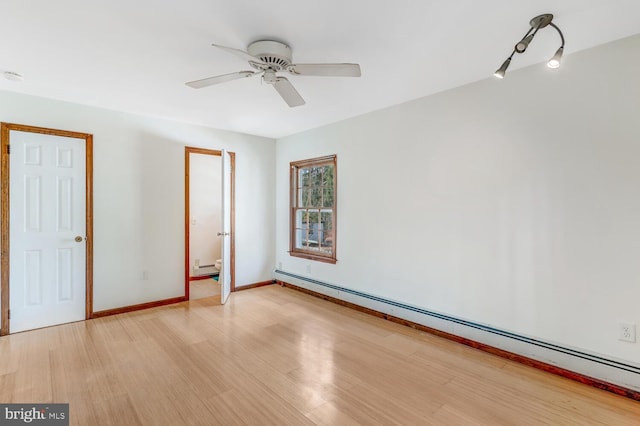 spare room featuring a baseboard heating unit, baseboards, light wood-style flooring, a ceiling fan, and a baseboard radiator