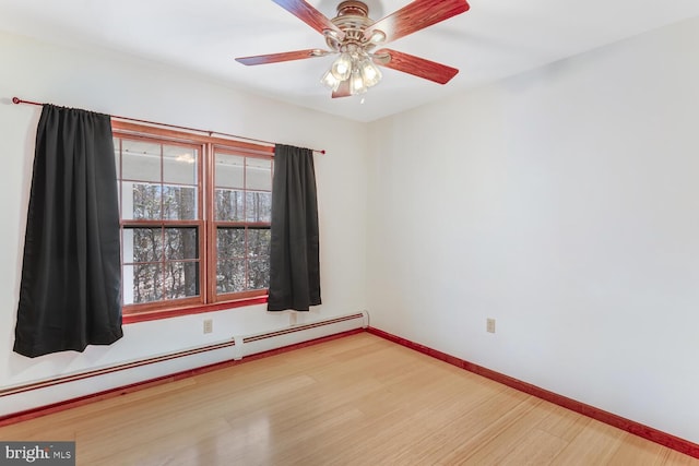 empty room with ceiling fan, baseboards, baseboard heating, and wood finished floors