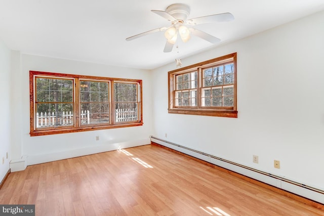 spare room featuring a ceiling fan, wood finished floors, and baseboard heating