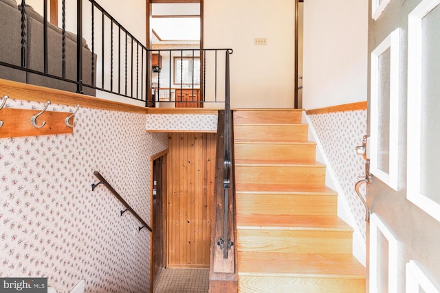 stairway featuring wallpapered walls