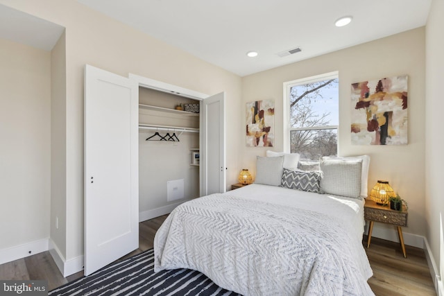 bedroom with visible vents, baseboards, and wood finished floors